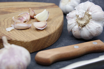 Organic garlic. Fresh garlic cloves and garlic bulb on a wooden cutting board. Garlic for healthy eating. Concept of spices for healthy cooking. Closeup