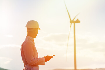 Engineer checks Wind Turbine system with a tablet. Alternative Energy. Wind farm. Clean renewable...
