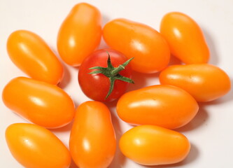 Fresh orange cherry tomatoes with red cherries in the middle isolated on a white background