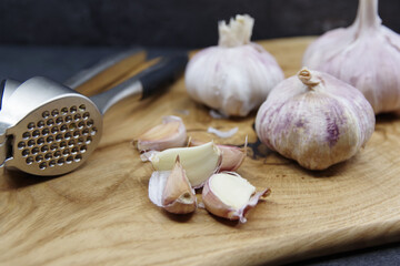 Organic garlic. Fresh garlic cloves and garlic bulb on a wooden cutting board. Garlic for healthy eating. Concept of spices for healthy cooking. Closeup