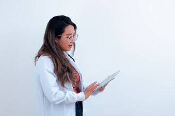 Latin American female doctor taking notes on a smart tablet
