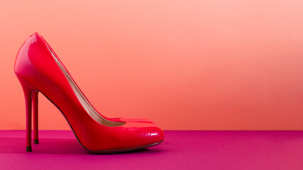 Elegant classic shoes close-up. Bright pink high heeled shoes. Pink and violet background.