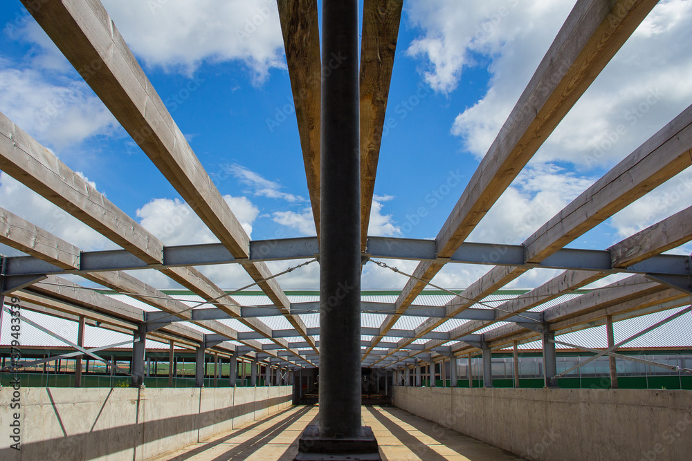 Poster The roof design. Wooden beams on a steel frame. Steel frame of a building under construction.