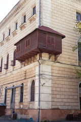 Naklejka premium ODESSA, UKRAINE - May 31, 2019: Antique wooden balcony with closed shutters. Ancient house in Odessa, Ukraine Views of Odessa in retro style.