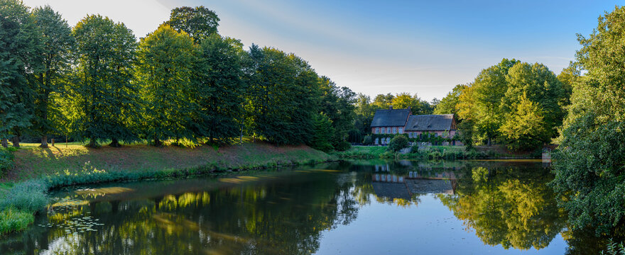 Panorama view of old country house and the pond in north Germany. The historic mill and the pond in the town of Ahrensburg, Schleswig Holstein, Germany