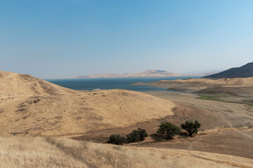 Obraz na płótnie Canvas The San Luis Reservoir during dry and hot season, artificial lake on San Luis Creek in the eastern slopes of the Diablo Range of Merced County, California. USA