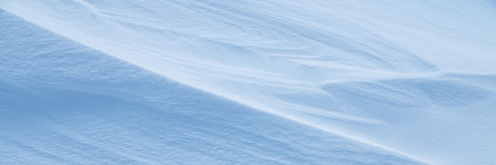 Snow texture. Wind sculpted patterns on snow surface. Wind in the tundra and in the mountains on the surface of the snow sculpts patterns and ridges. Arctic, Polar region. Winter panoramic background.