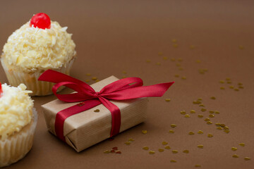 Gift boxes and vanilla cupcakes with cherry on top. Birthday concept. Sweet dessert with copy space.