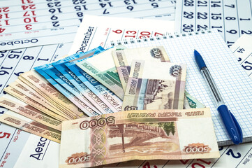 Russian money and a Notepad. A blue pen and Russian banknotes. A clean sheet and a blue pen.