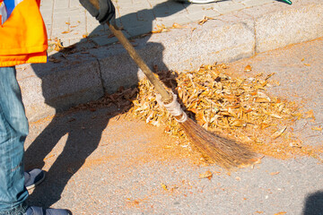 Autumn work in the park. Cleaning of fallen leaves.Cleaners clean the street from the fallen leaves...