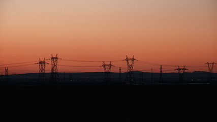 Fototapeta na wymiar power lines at sunset silhouette
