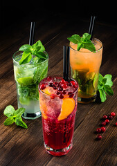 three refreshing cocktails on a wooden background