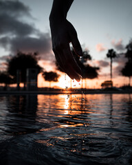 sunset on the river with hand dripping water