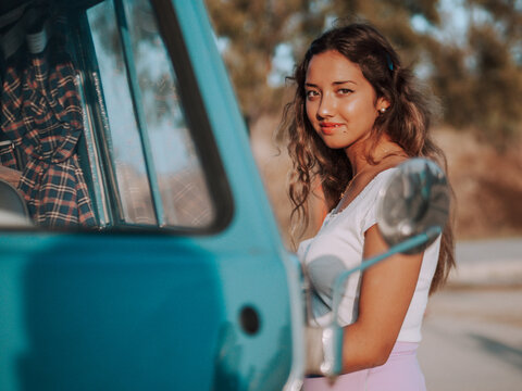 Mujer joven con una furgoneta azul