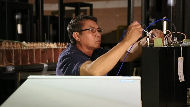 Asian electrical engineer with wrench testing computer component