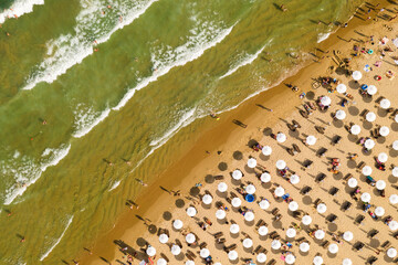 Aerial view from a drone. Beach with tourists, sunbeds and umbrellas. Travel background. Travel and vacation concept. Top view