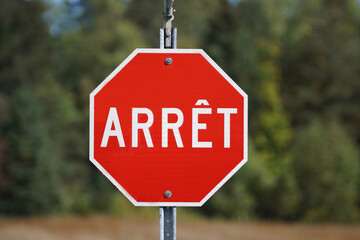 Close up of a french stop arret sign on an autumn forest background