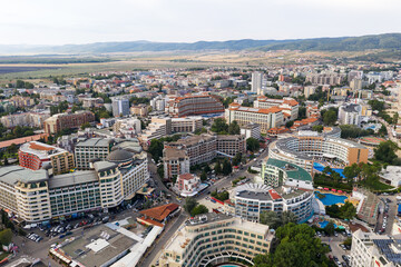 Obraz premium Suny Beach, Bulgaria - August 09, 2019: Aerial image a drone resort in Bulgaria on Black Sea coast. Many hotels and beaches with tourists, sunbeds and umbrellas. Sea travel destination. Travel
