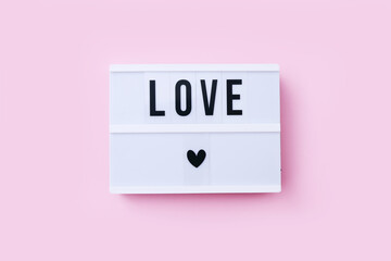 Lightboard with word Love on pink background. Valentine's day or wedding party concept.