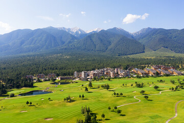 Fototapeta na wymiar Aerial view from drone. Stunning view of mountains and hotels of mountain resort Bansko in morning at dawn. Beautiful landscape of sunrise in mountains is shot from drone. Travel and vacation concept.