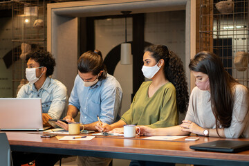 Serious brazilian group of entrepreneurs with face mask listening to meeting in office workspaceTeamwork, corporate, planning, strategy concept..
