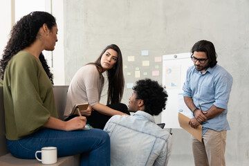 Professional latin teammates with attention discussing sales strategy and planning inside coworking office. Communication, workspace, meeting concept..