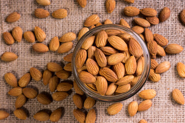Nueces en bol de vidrio encima de mesa de madera rustico con yute con cesta