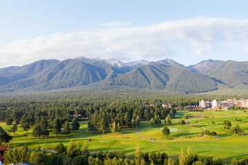 Obraz premium Aerial view from drone. Stunning view of mountains and hotels of mountain resort Bansko in morning at dawn. Beautiful landscape of sunrise in mountains is shot from drone. Travel and vacation concept.
