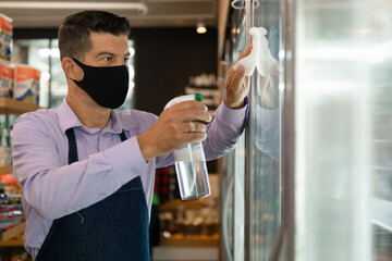 Professional brazilian worker with face mask cleaning workplace inside shop. business, workplace, successful, entrepreneur, occupation concept..