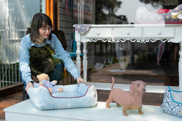 Happy latin female professional setting product in front of pet store facade. owner, small...