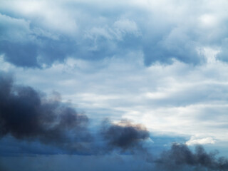 Obraz premium In the sky puffs of black smoke from fire. Contamination of the atmosphere, the environment. Global warming problem. As a background for any of your project.