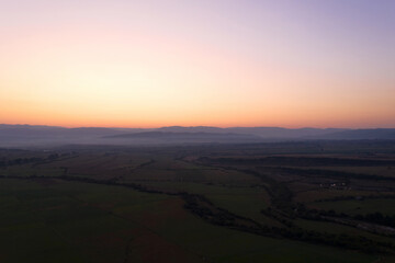 Fototapeta premium Aerial view from the drone. Stunning mountain and countryside view shot from a drone in the morning at dawn. Beautiful landscape of sunrise in the mountains