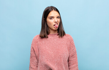 young pretty woman feeling disgusted and irritated, sticking tongue out, disliking something nasty...
