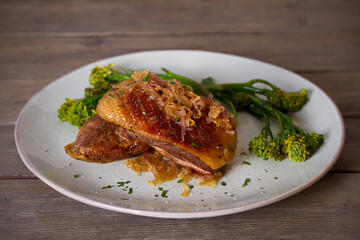 Roast duck breast fillets with vegetables on plate. vertical image