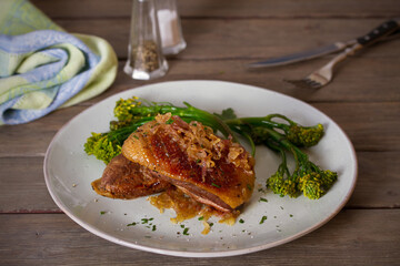 Roast duck breast fillets with vegetables on plate. vertical image