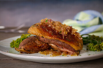 Roast duck breast fillets with vegetables on plate. vertical image
