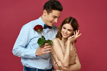 Lovers people with rose in hands on pink isolated background hug emotions happiness romance feelings