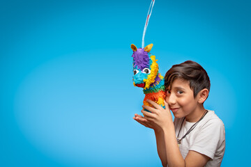 niño con piñata para celebracion y fiesta con fondo azul