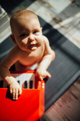 Creative baby playing a toy piano while learning music