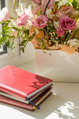 diary and mixed flowers bouquet on a white window sill. romance and love conceptual. copy space. lifestyles concept