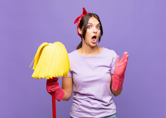 young pretty woman looking shocked and astonished, with jaw dropped in surprise when realizing...
