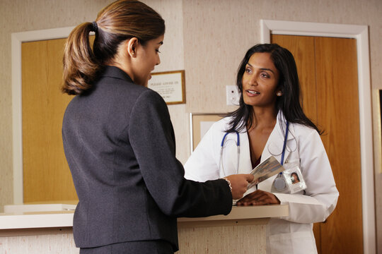 Doctor and businesswoman examining a brochure