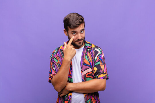 young man keeping an eye on you, not trusting, watching and staying alert and vigilant