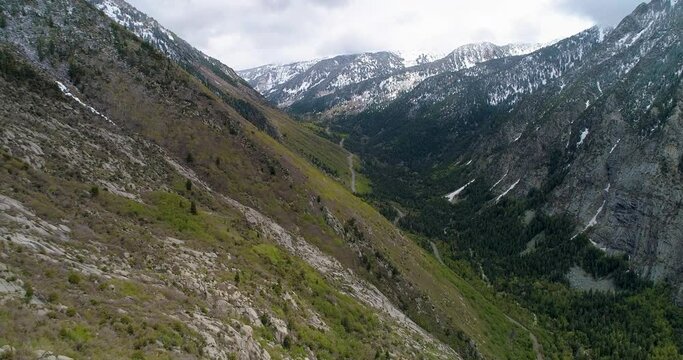 Drone footage flying up Little Cottonwood Canyon near Salt Lake City, Utah in the spring with snow still on the tops of the mountains