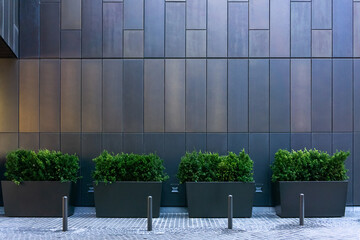 Big gray, metal planters with foliage plants nd terrace design with a modern mix of construction material