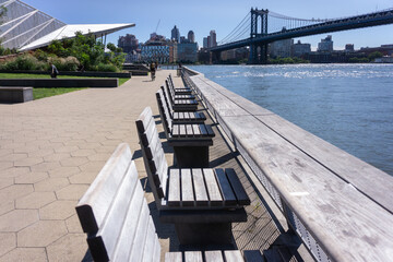 Pier 35 at East River Waterfront. Empty wooden benches along pier on Lower East Side, NYC