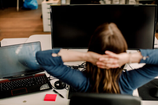 Rear view of entrepreneur sitting against computer in office