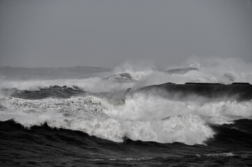 Dangerous waves in the middle of the ocean with spray from wind
