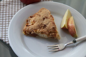 Apple pie on white plate. Apple and apple's pieces. Fork.