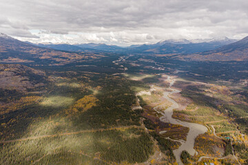 Aerial view of a winding river located in the northern Yukon Territory, Canada. Taken in the autumn with stunning yellow fall colored and snow capped mountains. 